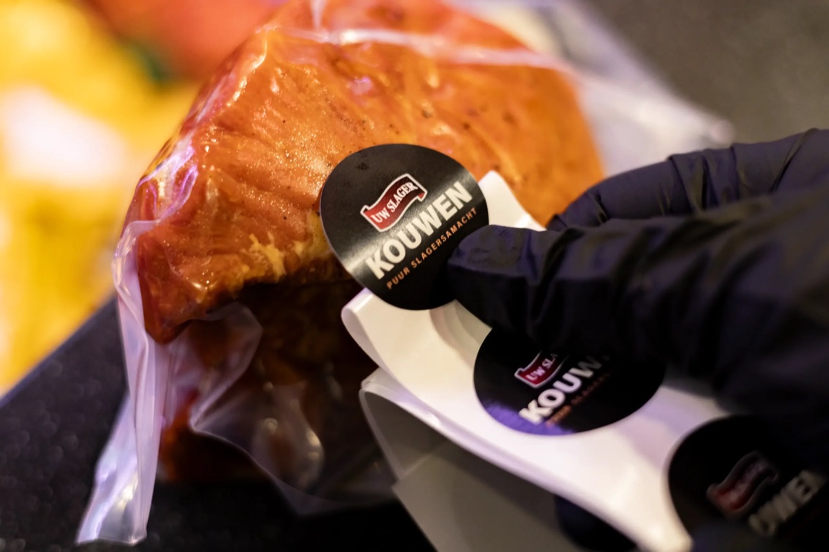 Ronde stickers worden op vleesverpakkingen geplakt